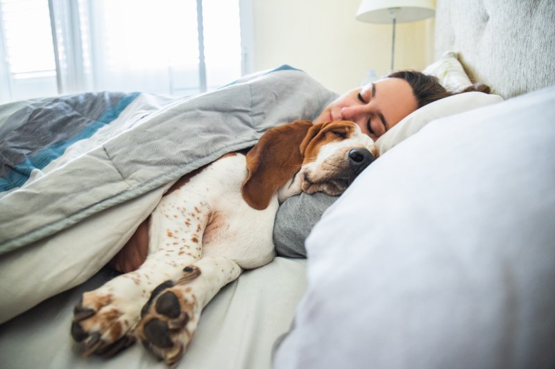 Woman sleeping next to dog