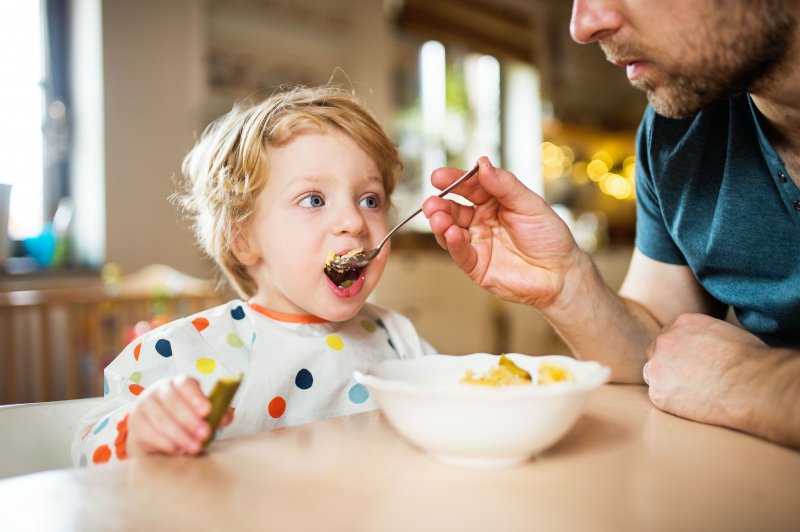 parent trying to feed toddler